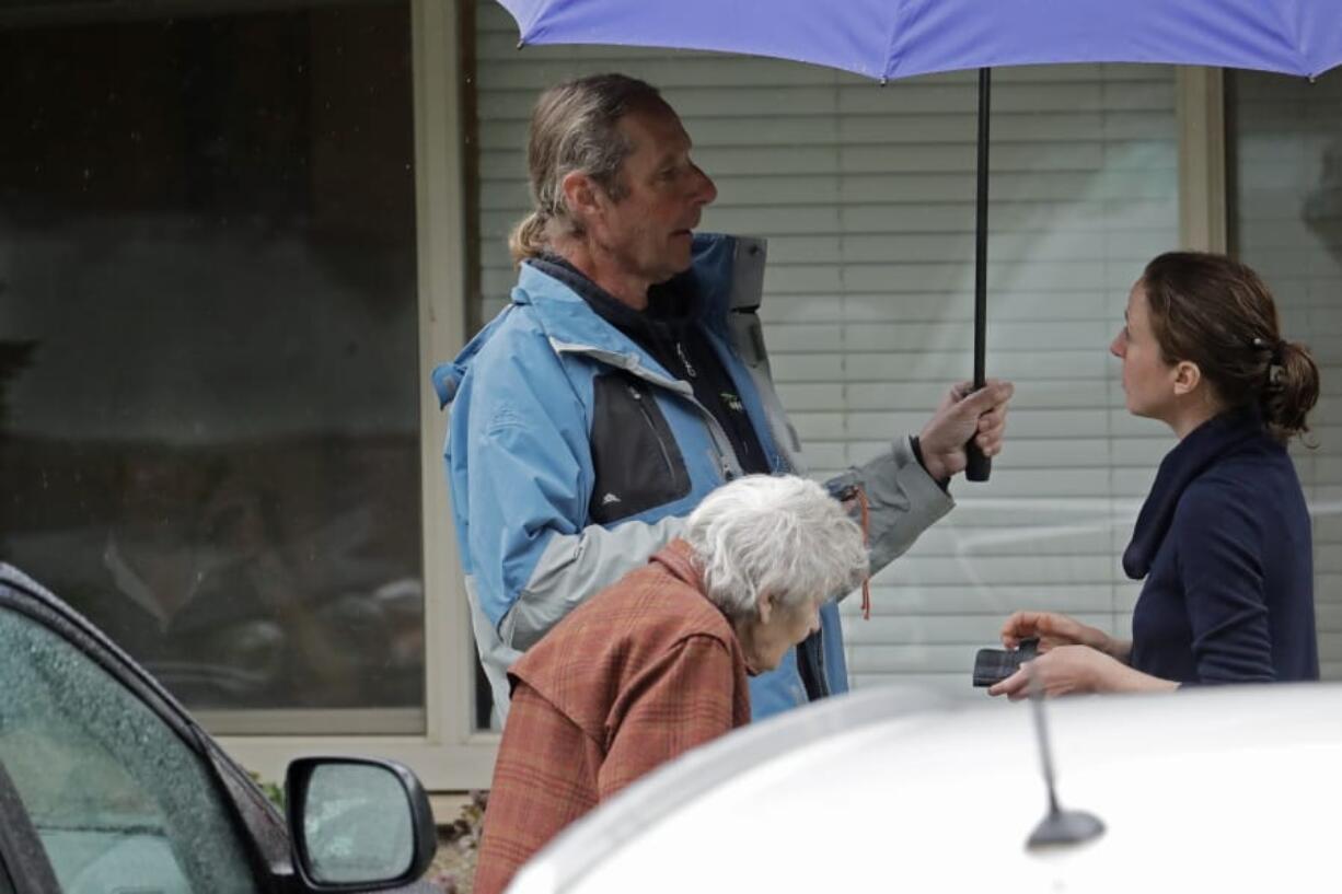 Charlie Campbell, center, stands with his mother, Dorothy Campbell, as they talk with a worker March 6 about his father, Gene Campbell, who can be seen through a window at left, at the Life Care Center in Kirkland. Charlie is nearly 13 years sober, but said he has been feeling tested due to stress from having his father now recovering from the coronavirus in a hospital. (Ted S.