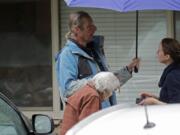 Charlie Campbell, center, stands with his mother, Dorothy Campbell, as they talk with a worker March 6 about his father, Gene Campbell, who can be seen through a window at left, at the Life Care Center in Kirkland. Charlie is nearly 13 years sober, but said he has been feeling tested due to stress from having his father now recovering from the coronavirus in a hospital. (Ted S.