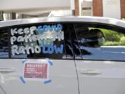 A driver paints protest signs on a car while participating in a drive-by demonstration outside of Providence Saint John&#039;s Health Center Tuesday, April 21, 2020, in Santa Monica, Calif. The hospital suspended ten nurses from their jobs last week after they refused to care for COVID-19 patients without being provided protective N95 face masks.