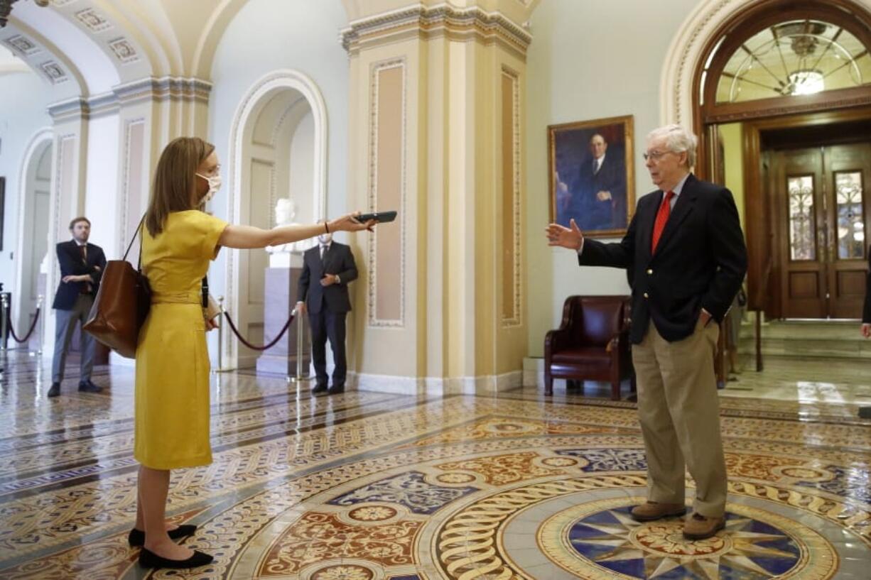 Senate Majority Leader Mitch McConnell of Ky., right, speaks with a reporter outside the Senate chamber on Capitol Hill in Washington, Thursday, April 9, 2020. Senate Democrats on Thursday stalled President Donald Trump&#039;s request for $250 billion to supplement a &quot;paycheck protection&quot; program for businesses crippled by the coronavirus outbreak, demanding protections for minority-owned businesses and money for health care providers and state and local governments.