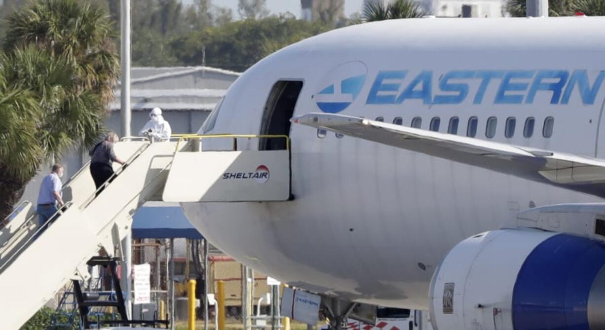 Passengers that came off the cruise ship Rotterdam Thursday, board a charter plane at Fort Lauderdale-Hollywood International Airport, Friday, April 3, 2020, in Fort Lauderdale, Fla. The Zaandam and a sister ship sent to help it, the Rotterdam, were given permission to unload passengers at Port Everglades on Thursday, after days of negotiations with officials who feared it would divert resources from a region with a spike in virus cases.