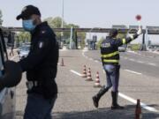 Police officers stop cars at the Melegnano highway barrier entrance, near Milan, Italy, Saturday, April 11, 2020. Using helicopters, drones and stepped-up police checks to make sure Italians don&#039;t slip out of their homes for the Easter holiday weekend, Italian authorities are doubling down on their crackdown against violators of the nationwide lockdown decree. The new coronavirus causes mild or moderate symptoms for most people, but for some, especially older adults and people with existing health problems, it can cause more severe illness or death.