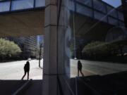 A person walks along a nearly empty street Wednesday, April 29, 2020, in Boston. Job cuts have escalated across the U.S. economy in recent days that remains all but shut down due measures taken to halt the spread of the virus.