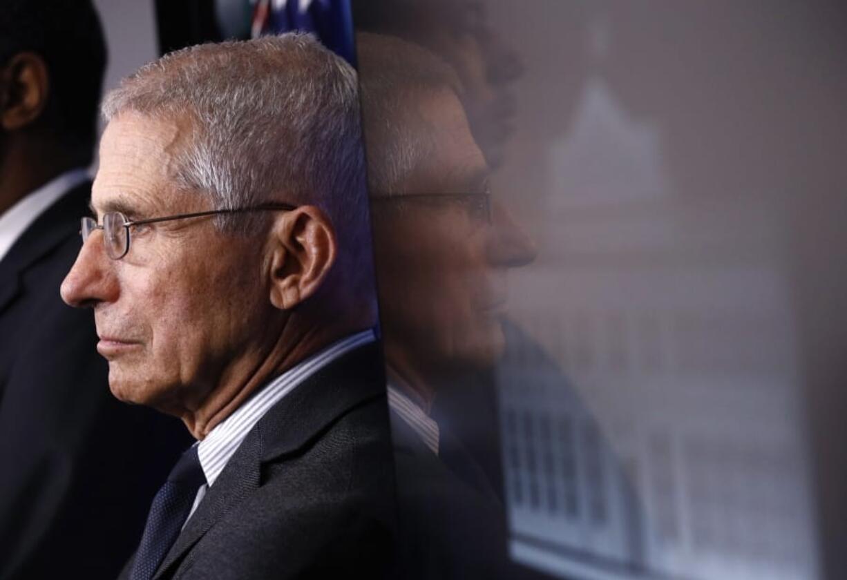 FILE - In this March 21, 2020 file photo, Director of the National Institute of Allergy and Infectious Diseases Dr. Anthony Fauci listens as President Donald Trump speaks during a coronavirus task force briefing at the White House in Washington.