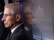 FILE - In this March 21, 2020 file photo, Director of the National Institute of Allergy and Infectious Diseases Dr. Anthony Fauci listens as President Donald Trump speaks during a coronavirus task force briefing at the White House in Washington.