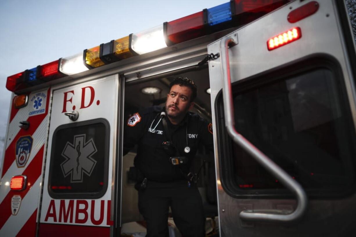 In this April 23, 2020, photo FDNY paramedic Alex Tull, who has recently recovered from COVID-19, prepares to begin his shift outside EMS station 26, the &quot;Tinhouse&quot;, in the Bronx borough of New York.