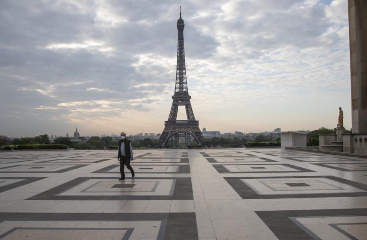 A man wears a mask to protect against the spread of the coronavirus as he walks along the Trocadero square close to the Eiffel Tower in Paris, Friday, April 24, 2020. France continues to be under an extended stay-at-home order until May 11 in an attempt to slow the spread of the COVID-19 pandemic.