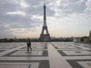 A man wears a mask to protect against the spread of the coronavirus as he walks along the Trocadero square close to the Eiffel Tower in Paris, Friday, April 24, 2020. France continues to be under an extended stay-at-home order until May 11 in an attempt to slow the spread of the COVID-19 pandemic.