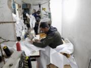 FLE - In this Monday, March 30, 2020 file photo, Palestinians make protective overalls meant to shield people from the coronavirus, to be exported to Israel, at a local factory, in Gaza City.