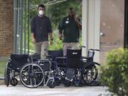 Wheelchairs are stacked at the curb outside PruittHealth Grandview nursing home where at least 10 patients who were previously tested presumptive positive for COVID-19 have passed away on Wednesday, April 8, 2020, in Athens, Ga. The facility continues to operate at an alert code red status following enhanced infectious disease protocol despite the deaths.