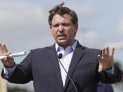 FILE - In this March 30, 2020, file photo Florida Gov. Ron DeSantis speaks during a news conference at a drive-through coronavirus testing site in front of Hard Rock Stadium in Miami Gardens, Fla.