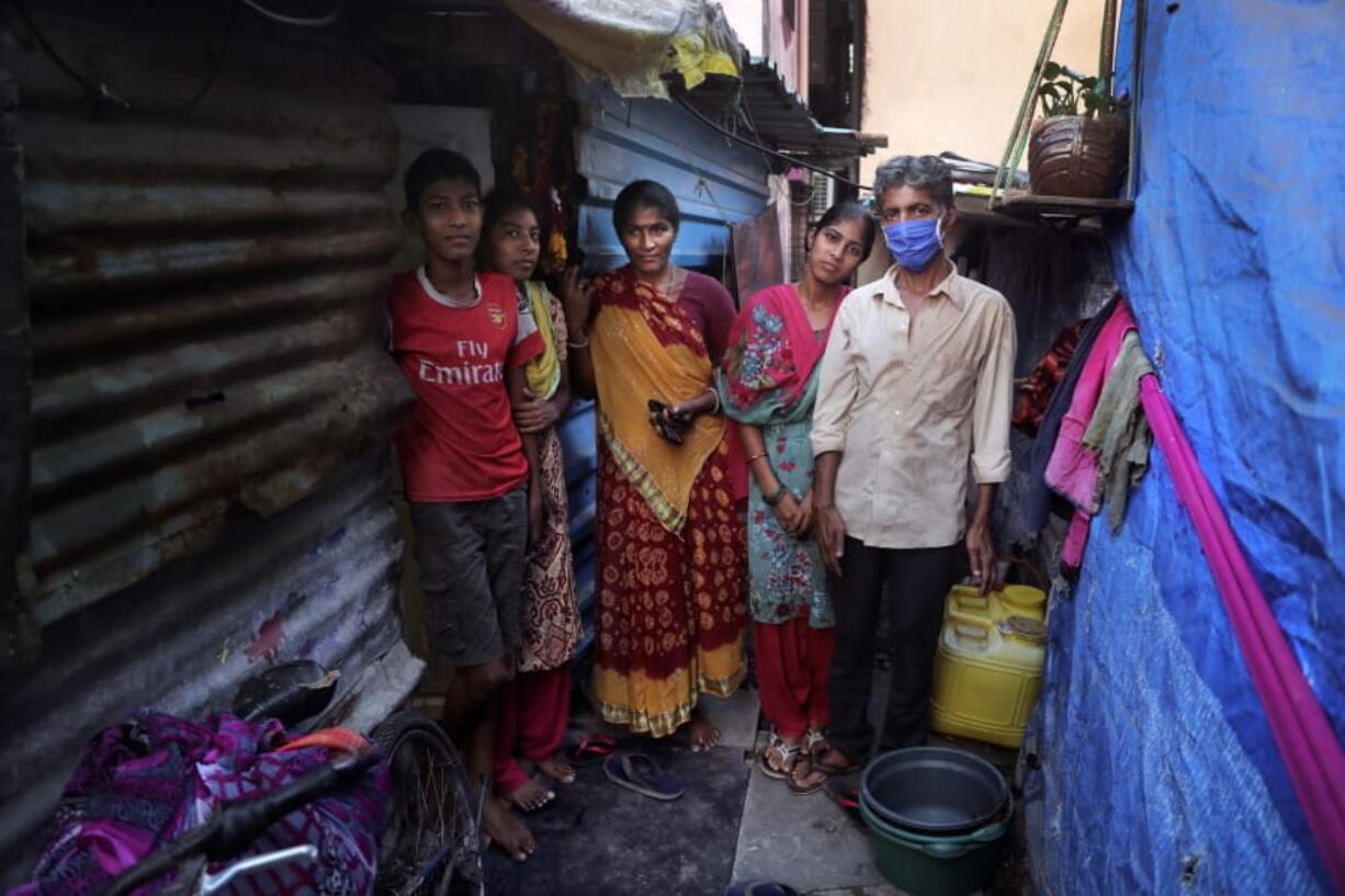 Mina Ramesh Jakhawadiya, center, stands with her family members, from left, son Ritik Ramesh, daughter Vaijayanti Ramesh, daughter Guddi Ramesh, and her husband, Ramesh Karsan Jakhawadiya, on April 3 outside their one-room home in Mumbai, India.