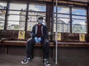 A man sits on a tram as signs reading &#039;please don&#039;t sit here, respect social distancing &#039;, are displayed on the benches, in Milan, Italy, Wednesday, April 29, 2020. Italian factories, construction sites and wholesale supply businesses can resume activity as soon as they put safety measures into place aimed at containing contagion with COVID-19.