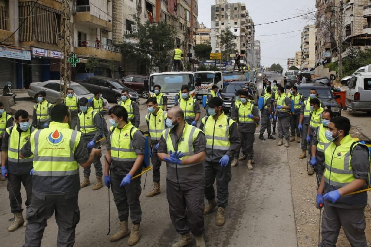 In this Friday, March 27, 2020 photo, members of the Islamic Health Society, an arm of the Iran-backed militant Hezbollah group prepare to spray disinfectant as a precaution against the coronavirus, in a southern suburb of Beirut, Lebanon. Hezbollah has mobilized the organizational might it once deployed to fight Israel or in Syria&#039;s civil war to battle the spread of the novel coronavirus. It aims to send a clear message to its Shiite supporters that it is a force to rely on in times of crisis -- particularly after it suffered a series of blows to its prestige. Opponents angrily accuse Hezbollah of helping bring the outbreak to Lebanon, saying it delayed a halt of flights from Iran for weeks after a woman who had just arrived from Iran emerged as Lebanon&#039;s first confirmed coronavirus case.