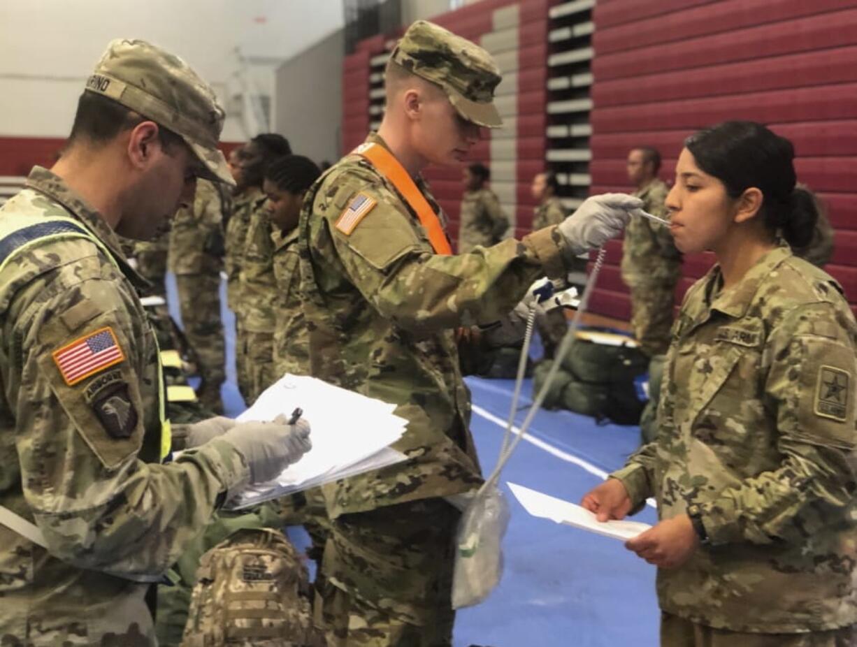 Recent Army basic combat training graduates have their temperatures taken as they arrive at Fort Lee, Va., on March 31. (U.S.