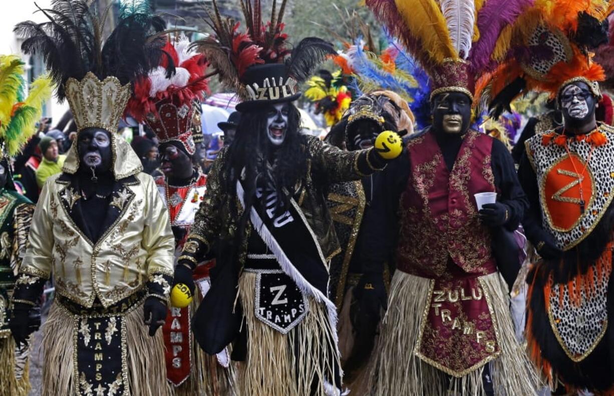 FILE - In this Tuesday, March 4, 2014, file photo, members of the Krewe of Zulu hold painted coconuts to give to paradegoers, as they march during Mardi Gras in New Orleans. In a city ravaged by the coronavirus outbreak, Zulu and its members have paid a heavy price. Several of the group&#039;s members have died from coronavirus-related complications, said Zulu President Elroy A. James. Multiple other members have tested positive.