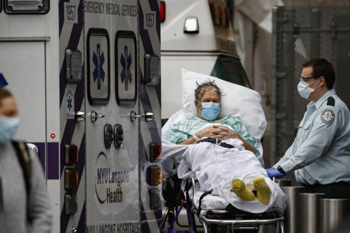 Patients and medical workers wear personal protective equipment due to COVID-19 concerns outside the emergency room at NYU Langone Medical Center, Monday, April 13, 2020, in New York. The new coronavirus causes mild or moderate symptoms for most people, but for some, especially older adults and people with existing health problems, it can cause more severe illness or death.