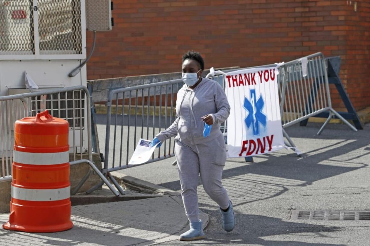 A woman leaves Elmhurst Hospital Center after being tested for COVID-19 or coronavirus during the current viral pandemic, Tuesday, April 7, 2020, in the Queens borough of New York. The new coronavirus causes mild or moderate symptoms for most people, but for some, especially older adults and people with existing health problems, it can cause more severe illness or death.