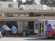 A person is loaded into an ambulance at Life Care Center in Kirkland, which has been at the center of the COVID-19 coronavirus outbreak in the state. Residents of assisted living facilities and their loved ones are facing a grim situation as the coronavirus spreads across the country, placing elderly people especially at risk. (AP Photo/Ted S.