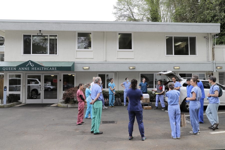 In this Friday, April 17, 2020, photo, Dr. Thaun Ong, just right of center, holds a notepad while he gives instructions to a team of University of Washington medical providers as they prepare to conduct testing for the new coronavirus at Queen Anne Healthcare, a skilled nursing and rehabilitation facility in Seattle. Sending &quot;drop teams&quot; from University of Washington Medicine to conduct universal testing at skilled nursing facilities in collaboration with public health officials is one aspect of the region&#039;s approach to controlling the spread of the coronavirus. (AP Photo/Ted S.