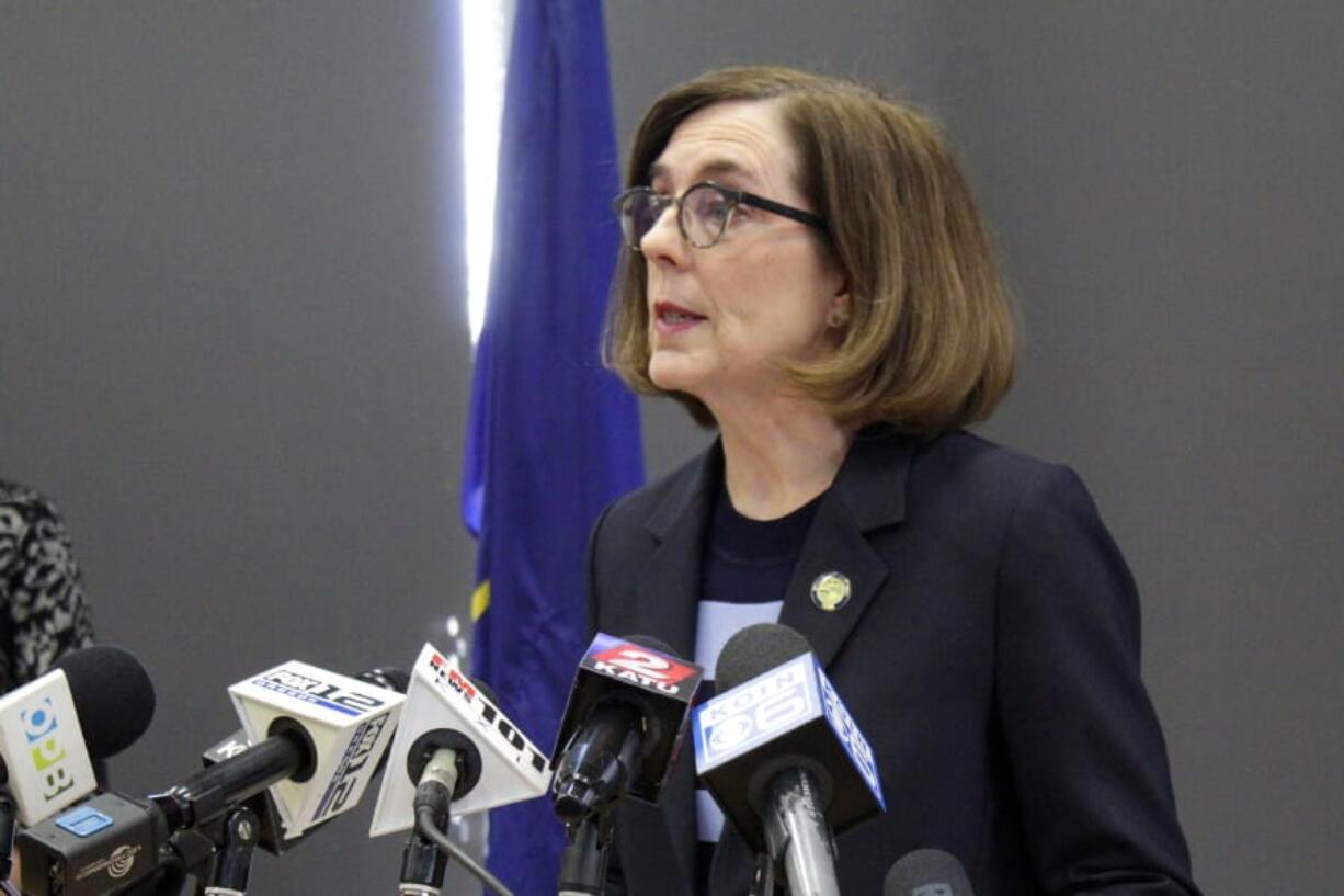 FILE - In this March 16, 2020, file photo, Oregon Gov. Kate Brown speaks at a news conference in Portland, Ore., to announce a four-week ban on eat-in dining at bars and restaurants, due to COVID-19, throughout the state. Oregon is in its fourth week of lockdown. Of all the states, Oregon should have the fewest COVID-19 deaths per capita when the peak comes here, according to researchers at the University of Washington who developed a closely watched model.