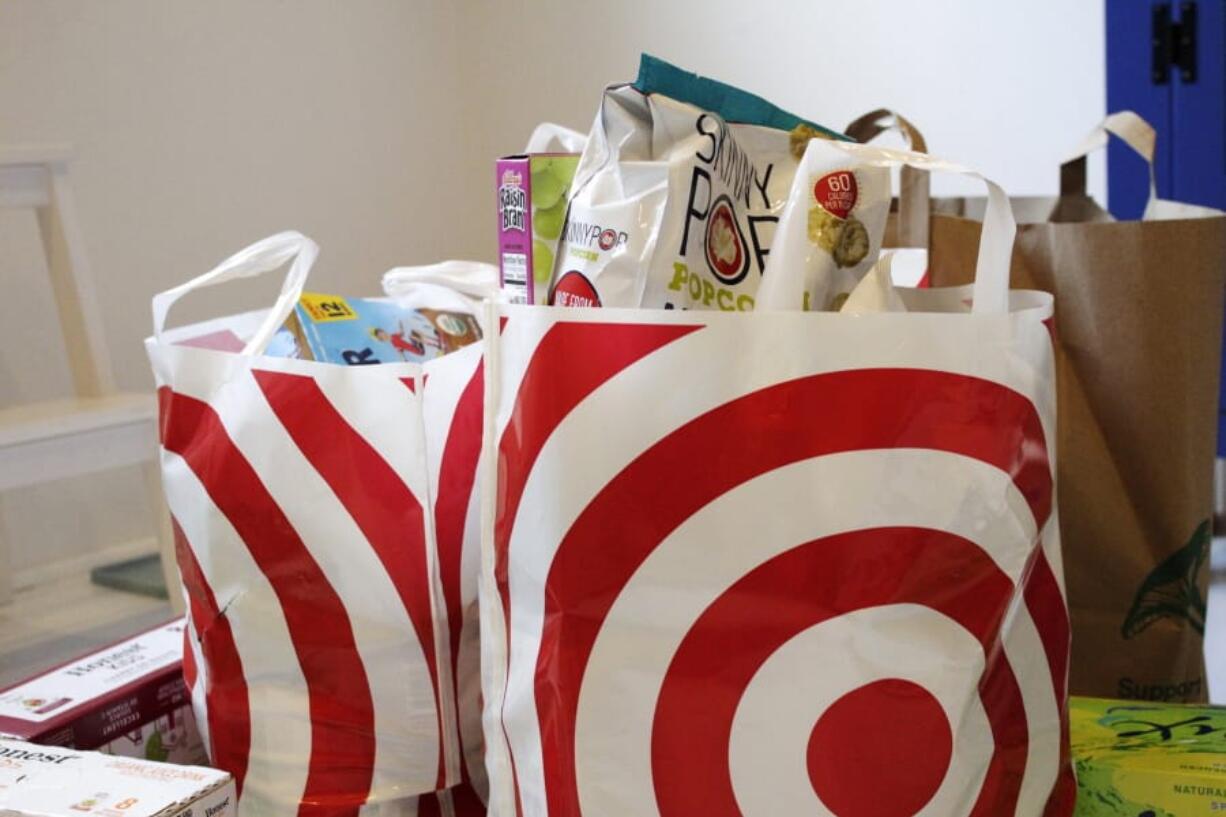 In this Sunday, March 29, 2020, photo, groceries loaded in plastic bags are seen after a shopping trip in Portland, Ore. Just weeks earlier, cities and even states across the U.S. were busy banning straws, limiting takeout containers and mandating that shoppers bring reusable bags or pay a small fee. Grocery clerks are nervous that the virus could linger on reusable fabric bags and their unions are backing them up with demands to end plastic bag fees and suspend bag bans. The plastics industry has seized the moment, lobbying to overturn existing bans on single-use plastics.