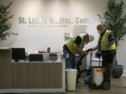 In this April 23, 2020, photo, contract workers join the Army Corps of Engineers as they get the currently dormant St. Luke&#039;s Hospital ready for reopening for the possible surge of coronavirus patients in Phoenix. As states gear up to reopen, a poll finds a potential obstacle to controlling coronavirus: nearly 1 in 10 adults say cost would keep them from seeking help if they thought they were infected. The Gallup-West Health Healthcare Costs Survey out Tuesday, April 28, finds that 9% of those age 18 and over would avoid seeking treatment because of concerns about the cost of care, even if they thought they were infected with the coronavirus.  (AP Photo/Ross D.