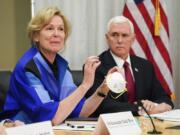 FILE - In this March 5, 2020, file photo, Dr. Deborah Birx, Ambassador and White House coronavirus response coordinator, holds a 3M N95 mask as Vice President Mike Pence visits 3M headquarters in Maplewood, Minn., in a meeting with 3M leaders and Minnesota Gov. Tim Walz to coordinate response to the COVID-19 virus. A review of federal purchasing contracts by The Associated Press shows federal agencies waited until mid-March to begin placing bulk orders of N95 respirator masks, mechanical ventilators and other equipment needed by front-line health care workers.