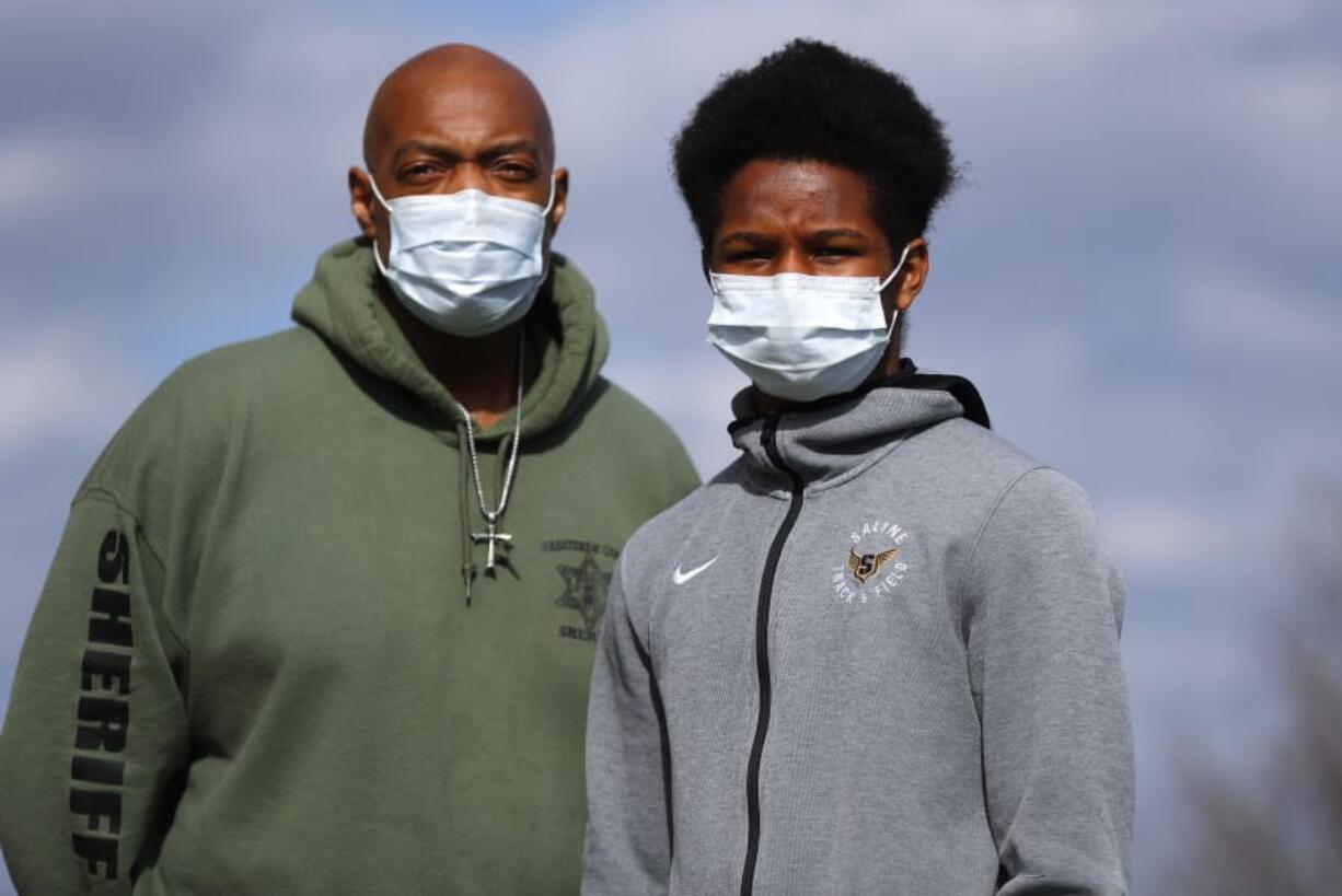 Washtenaw County Sheriff&#039;s Department Sgt. Eugene Rush, who was diagnosed with the coronavirus near the end of March, stands with his son, Joshua, 16, on Thursday in Superior Township, Mich. Joshua has also been diagnosed with COVID-19, are both on the mend and resting at home.