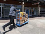 Cameron Webb, an employee with McLane Company, makes a delivery to a Family Dollar in Dallas, Wednesday, April 15, 2020.