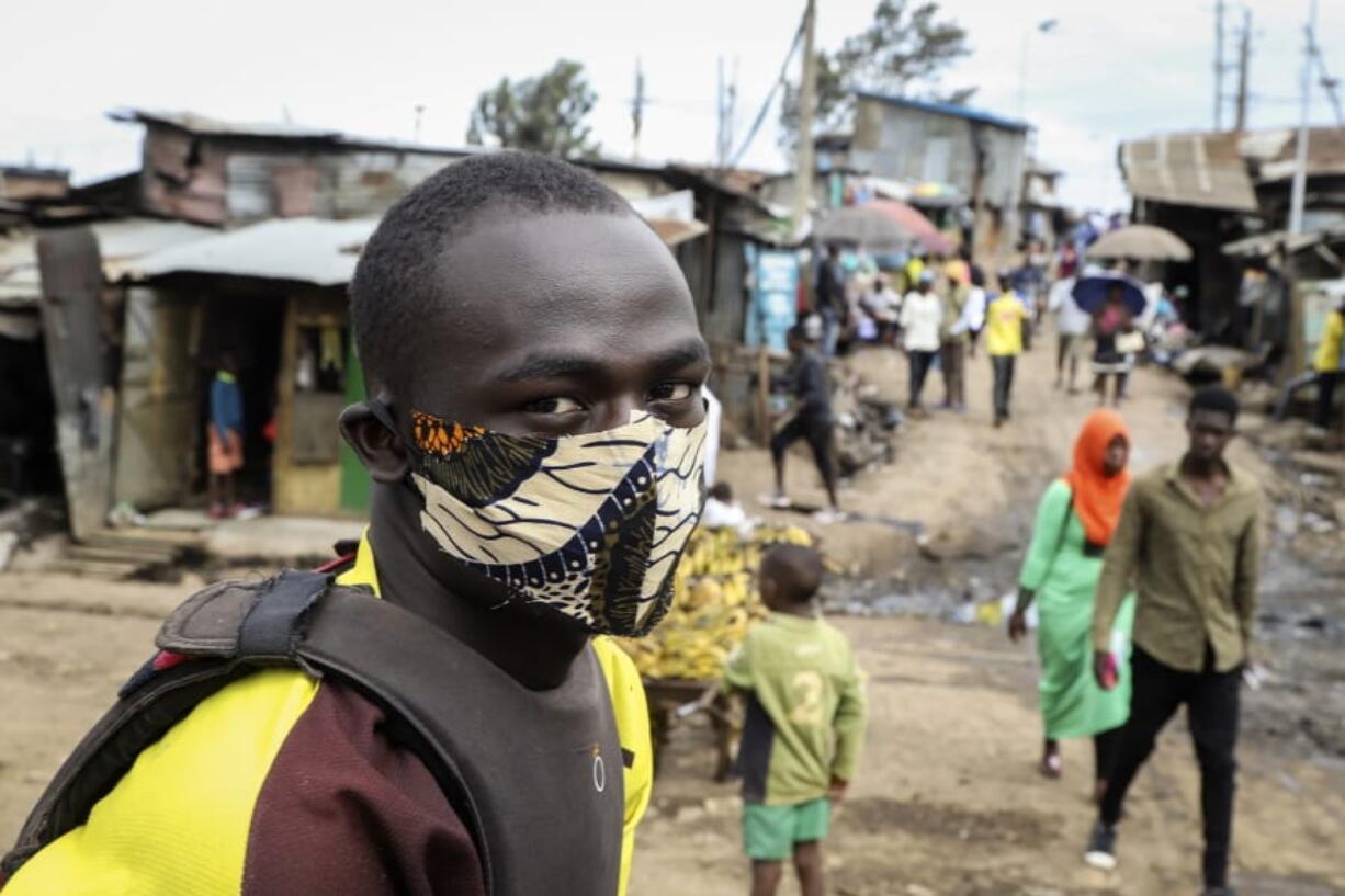 FILE - In this March 20, 2020, file photo, a boda-boda, or motorcycle taxi, driver wears a makeshift mask made from a local fabric known as Kitenge as he looks for customers in the Kibera neighborhood of Nairobi, Kenya. As Africa braces for a surge in coronavirus cases, its countries are far behind in the global race for medical equipment. Outbid or outmaneuvered by richer nations, jolting African officials to scramble for solutions and join forces, creating a pooled purchasing platform under the African Union to improve their negotiating power.