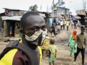 FILE - In this March 20, 2020, file photo, a boda-boda, or motorcycle taxi, driver wears a makeshift mask made from a local fabric known as Kitenge as he looks for customers in the Kibera neighborhood of Nairobi, Kenya. As Africa braces for a surge in coronavirus cases, its countries are far behind in the global race for medical equipment. Outbid or outmaneuvered by richer nations, jolting African officials to scramble for solutions and join forces, creating a pooled purchasing platform under the African Union to improve their negotiating power.