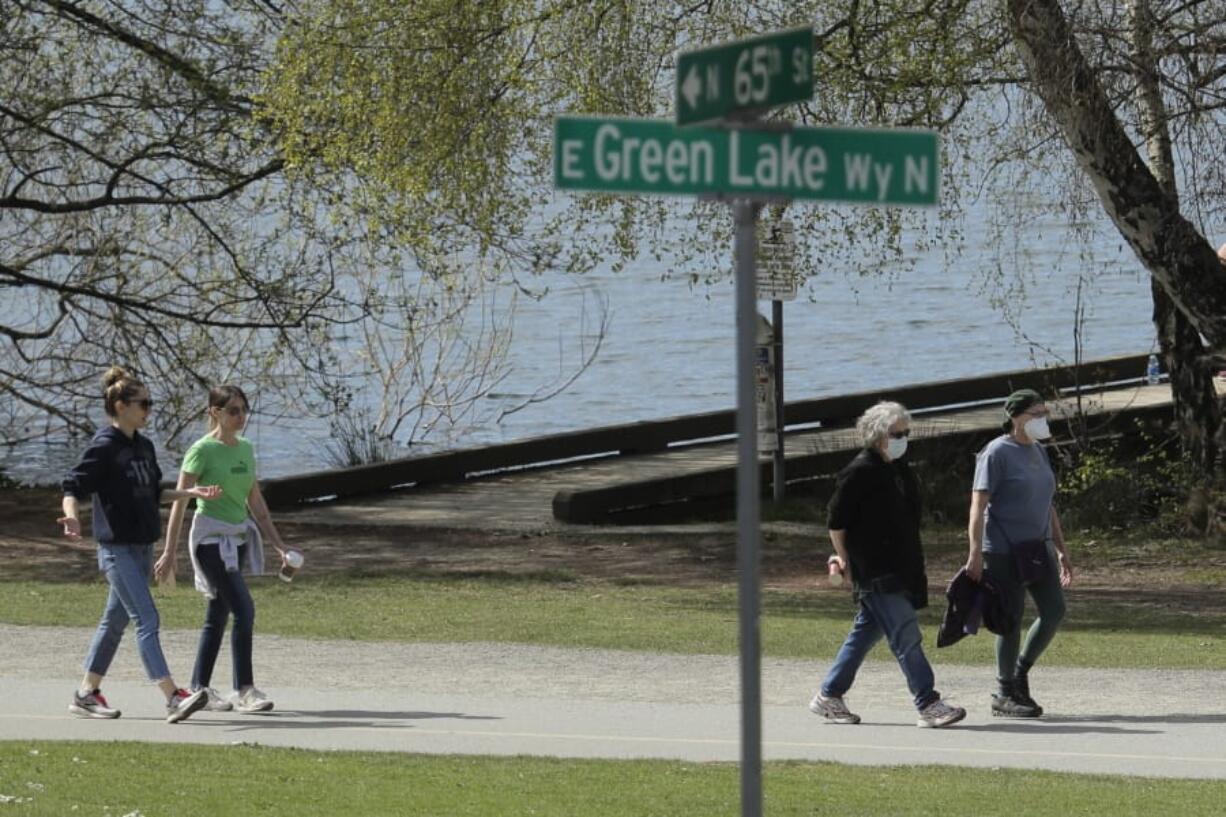 Some people wearing masks, and some not, walk on a pathway at Green Lake Park, Friday, April 10, 2020, in Seattle. In hopes of stopping group gatherings and exercise where social distancing isn&#039;t being practiced, City of Seattle officials plan to close the entire park and more than a dozen others over the Easter weekend to try and continue slowing the spread of the coronavirus, but many fear warm weather and weariness of Washington state&#039;s stay-at-home order could still drive people outside. (AP Photo/Ted S.