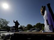 Pastor Albert &quot;Gonzo&quot; Gonzales stands on a flat-bed truck as his church holds Easter services in the parking log in San Antonio, Sunday, April 12, 2020. Many churches are adapting their services as Christians around the world are celebrating Easter at a distance due to the COVID-19 pandemic.