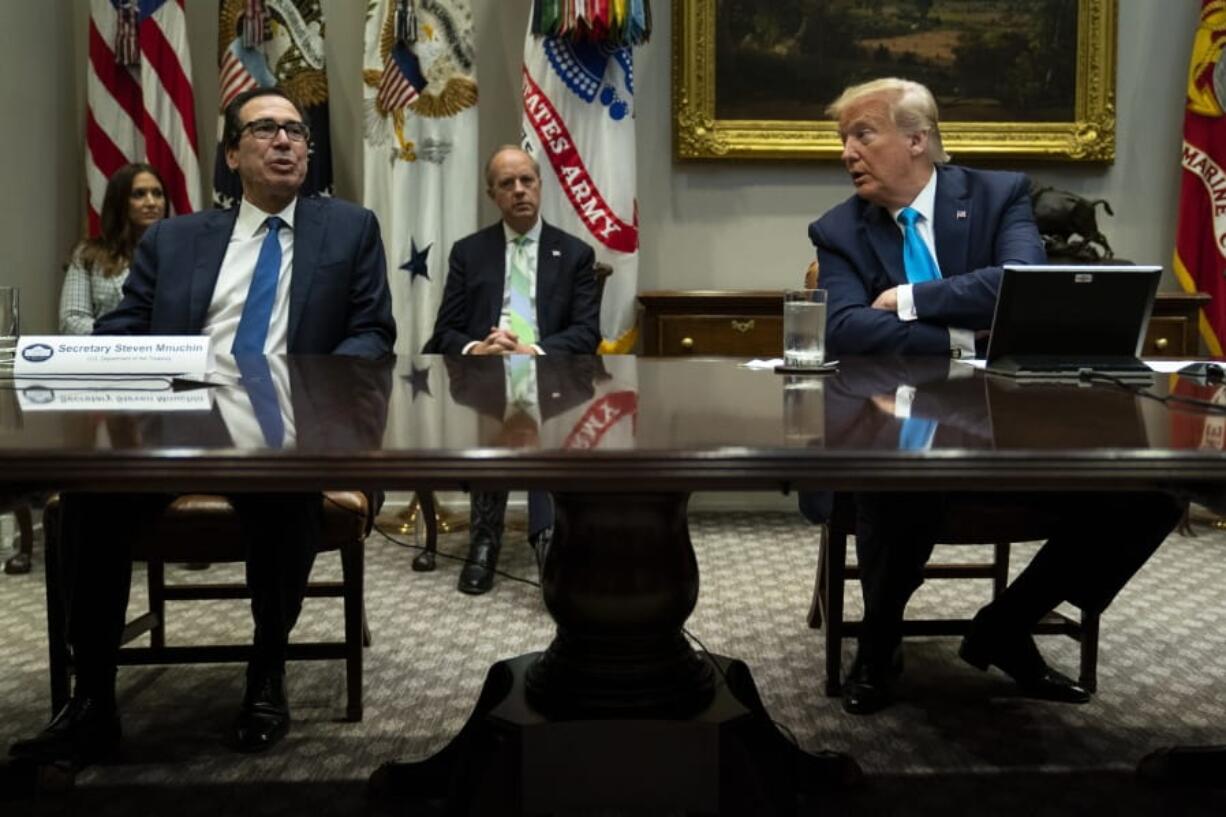 President Donald Trump listens as Treasury Secretary Steven Mnuchin speaks during a conference call with banks on efforts to help small businesses during the coronavirus pandemic, at the White House, Tuesday, April 7, 2020, in Washington.