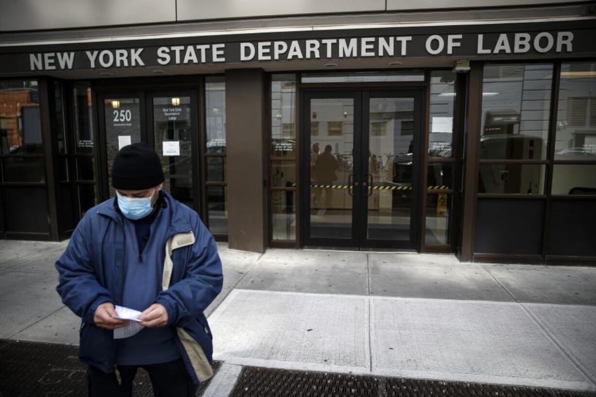 FILE - In this Wednesday, March 18, 2020 file photo, Visitors to the Department of Labor are turned away at the door by personnel due to closures over coronavirus concerns in New York. Americans are seeking unemployment benefits at unprecedented levels due to the coronavirus, but many are finding more frustration than relief.