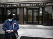 FILE - In this Wednesday, March 18, 2020 file photo, Visitors to the Department of Labor are turned away at the door by personnel due to closures over coronavirus concerns in New York. Americans are seeking unemployment benefits at unprecedented levels due to the coronavirus, but many are finding more frustration than relief.