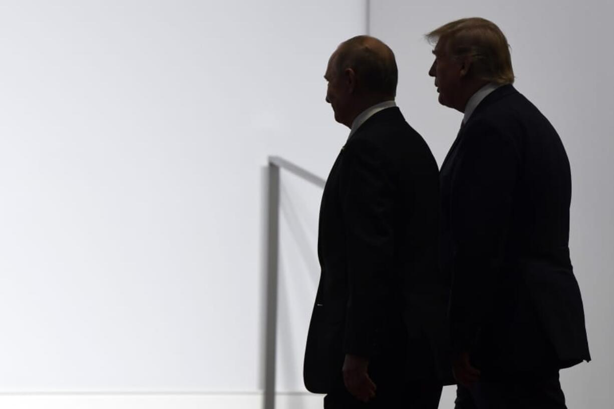 FILE - In this June 28, 2019, file photo, President Donald Trump and Russian President Vladimir Putin walk to participate in a group photo at the G20 summit in Osaka, Japan. An odd new front in the U.S.-Russian rivalry has emerged as a Russian military cargo plane bearing a load of urgently needed medical supplies landed in New York&#039;s JFK airport.