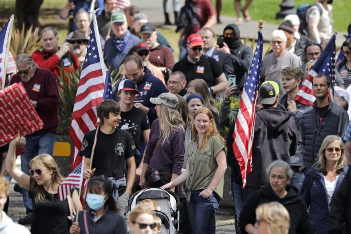 Demonstrators disregard social distancing guidelines as they crowd together at a protest opposing Washington state&#039;s stay-home order to slow the coronavirus outbreak Sunday, April 19, 2020, in Olympia, Wash. Washington Gov. Jay Inslee has blasted President Donald Trump&#039;s calls to &quot;liberate&quot; parts of the country from stay-at-home and other orders that are designed to combat the spread of the coronavirus. Inslee says that Trump is fomenting a potentially deadly &quot;insubordination&quot; among his followers before the pandemic is contained.