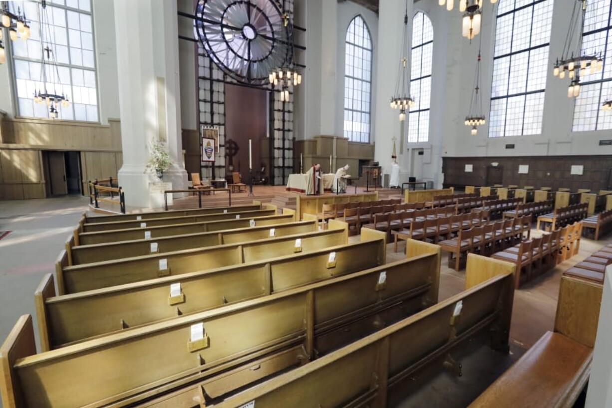 The Very Rev. Steven L. Thomason, left, and the Right Rev. Gregory H. Rickel, bow to an empty sanctuary as they begin a live streamed Easter service at Saint Mark&#039;s Episcopal Cathedral Sunday, April 12, 2020, in Seattle. Christians around the world are celebrating Easter at a distance, with many churches closed and family gatherings canceled amid wide-ranging shutdowns due to the coronavirus pandemic.