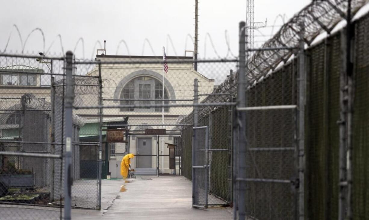 FILE - In this Jan. 28, 2016, file photo, a man does maintenance work between razor wire-topped fences at the Monroe Correctional Complex in Monroe, Wash. Inmates at the prison filed a motion Thursday, April 9, 2020, with the Washington state Supreme Court asking it to order Gov. Jay Inslee and Department of Corrections Secretary Stephen Sinclair to release inmates who are 60 years old or older, those with underlying health conditions, and any who are close to their release date after almost a dozen people at the prison tested positive for the new coronavirus.