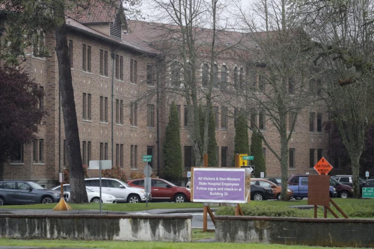 In this April 22, 2020, photo, a sign at Western State Hospital in Lakewood, Wash., directs visitors and non-hospital employees to check in at another building where health screening is done. Employees at the facility -- the state&#039;s largest psychiatric hospital -- say that problems with testing for the coronavirus likely produced inaccurate results and exposed them to the virus a second time. (AP Photo/Ted S.