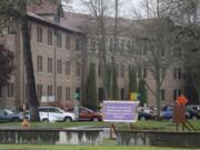 In this April 22, 2020, photo, a sign at Western State Hospital in Lakewood, Wash., directs visitors and non-hospital employees to check in at another building where health screening is done. Employees at the facility -- the state&#039;s largest psychiatric hospital -- say that problems with testing for the coronavirus likely produced inaccurate results and exposed them to the virus a second time. (AP Photo/Ted S.