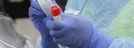 A nurse holds a vial and a swab at a drive-up coronavirus testing station in Seattle earlier this month. More options for testing are becoming available in Clark County. (Ted S.