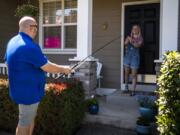 Mountain View High School teacher and coach Dan Larson uses a fishing pole to drop off materials for a fishing license for senior Abby Horton at her home in Vancouver. Larson asked his senior students to all tell him a small thing they wished for that he could help come true. Throughout the last few weeks he&#039;s been completing one of these small acts of kindness for at least one of his students a day.