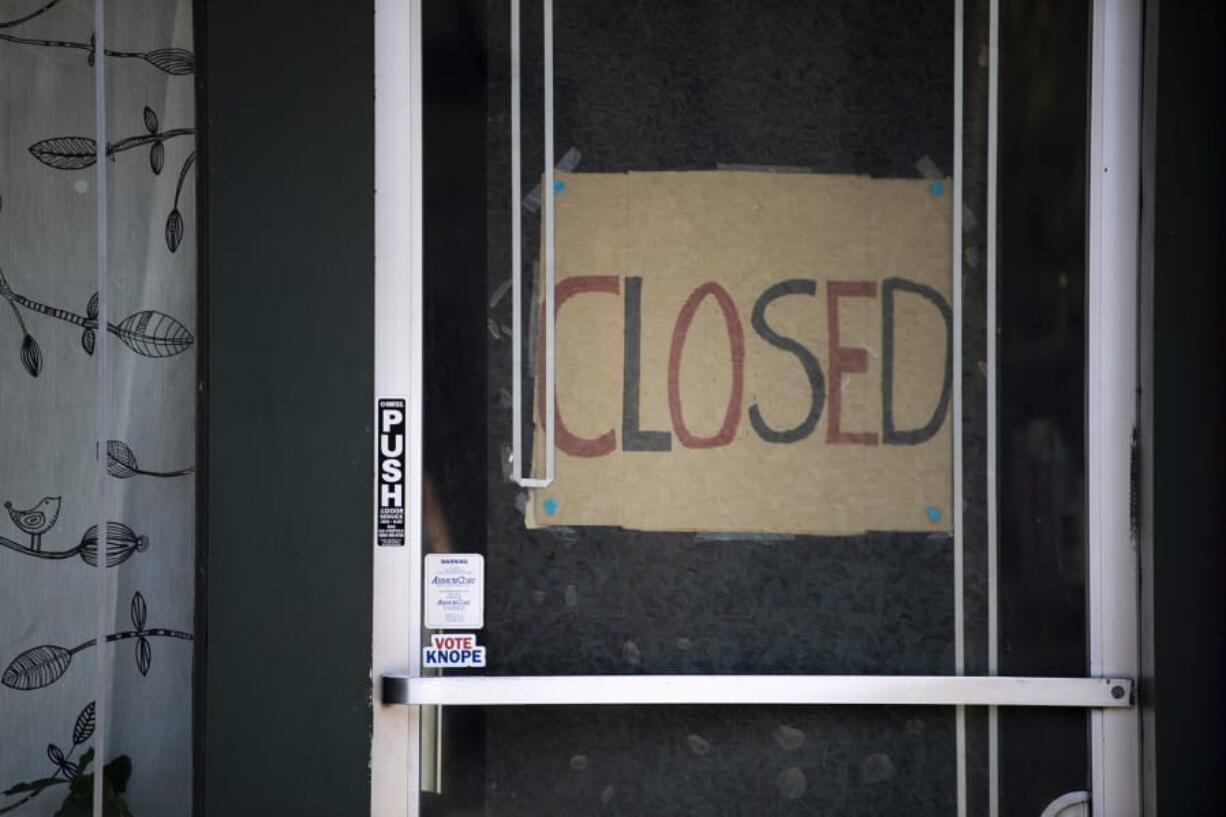 A closed sign is pictured in the door of Simple Solitude in Vancouver on April 20.