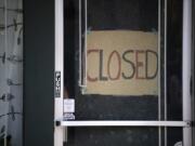 A closed sign is pictured in the door of Simple Solitude in Vancouver on April 20.