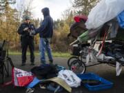 Tyler Chavers, Vancouver&#039;s homeless assistance response team officer, left, talks with Shawn Fernandez during the 2020 Point in Time count near Leverich Park on Jan. 30.