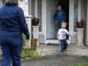 Christina Kragness&#039; kids Wyatt, 8, center, and Cody, 3, right, run out of their house in excitement as she stops by for a distanced visit at their home in Vancouver. Kragness is an ICU nurse at PeaceHealth Southwest Medical center. She moved out of the home to protect her family from the virus. Her husband is in a higher-risk category for the virus.