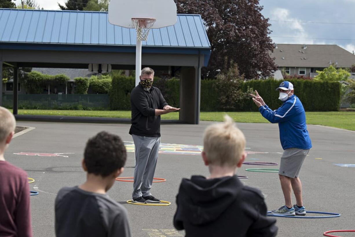 Union's Rory Rosenbach, left, and Mountain View's Adam Mathieson demonstrate how to navigate through a game that involves no contact and rock, paper, scissors for youngsters at Crestline Elementary School on Monday afternoon, April 27, 2020.